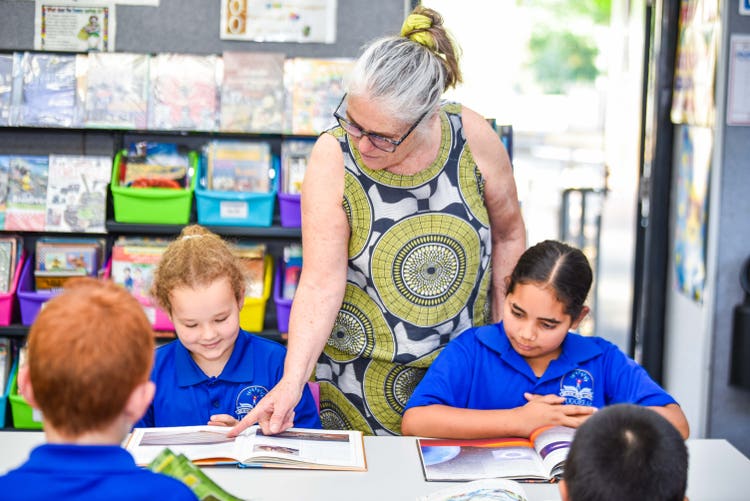 librarian with three students reading