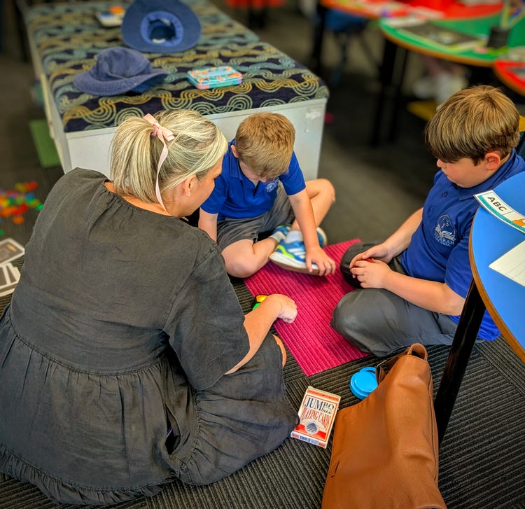 teacher sitting with 2 students